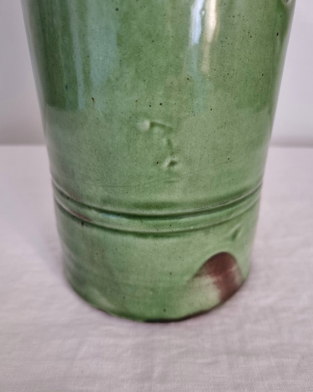 Tall studio pottery leaf green glazed water pitcher jug with twisted handle and banded centre. Marked Schofield Penrith.