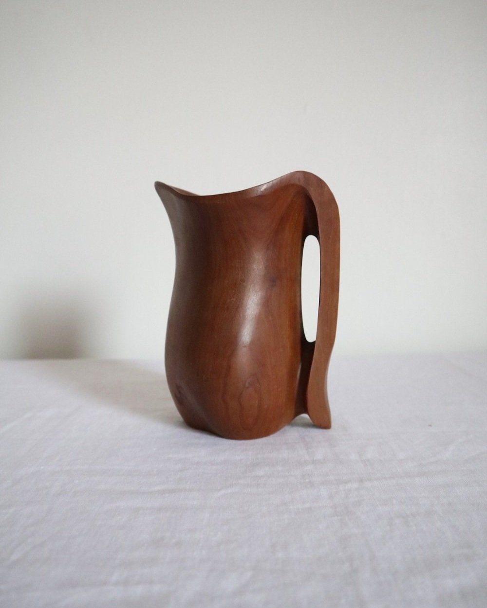 Small sculptural hand carved dark olivewood monoxyl pitcher, circa 1960/70s. In the manner of Alexandre Noll. Unsigned.