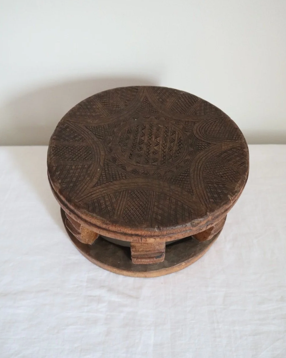 Vintage Nigerian small circular low stool carved from one piece of wood with decorative etchings to surface.