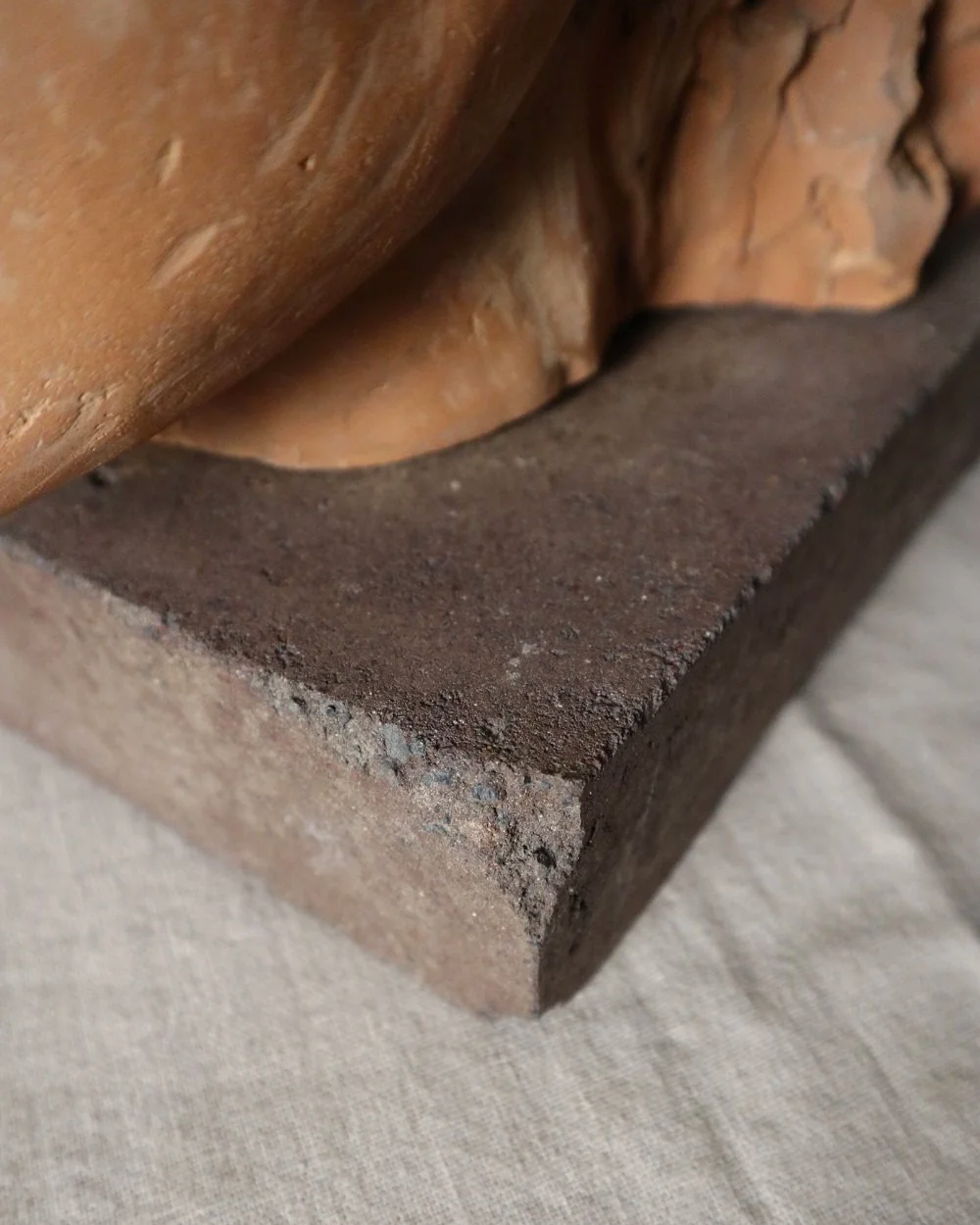 A signed, 20th century art studio terracotta female bust with stone display plinth.