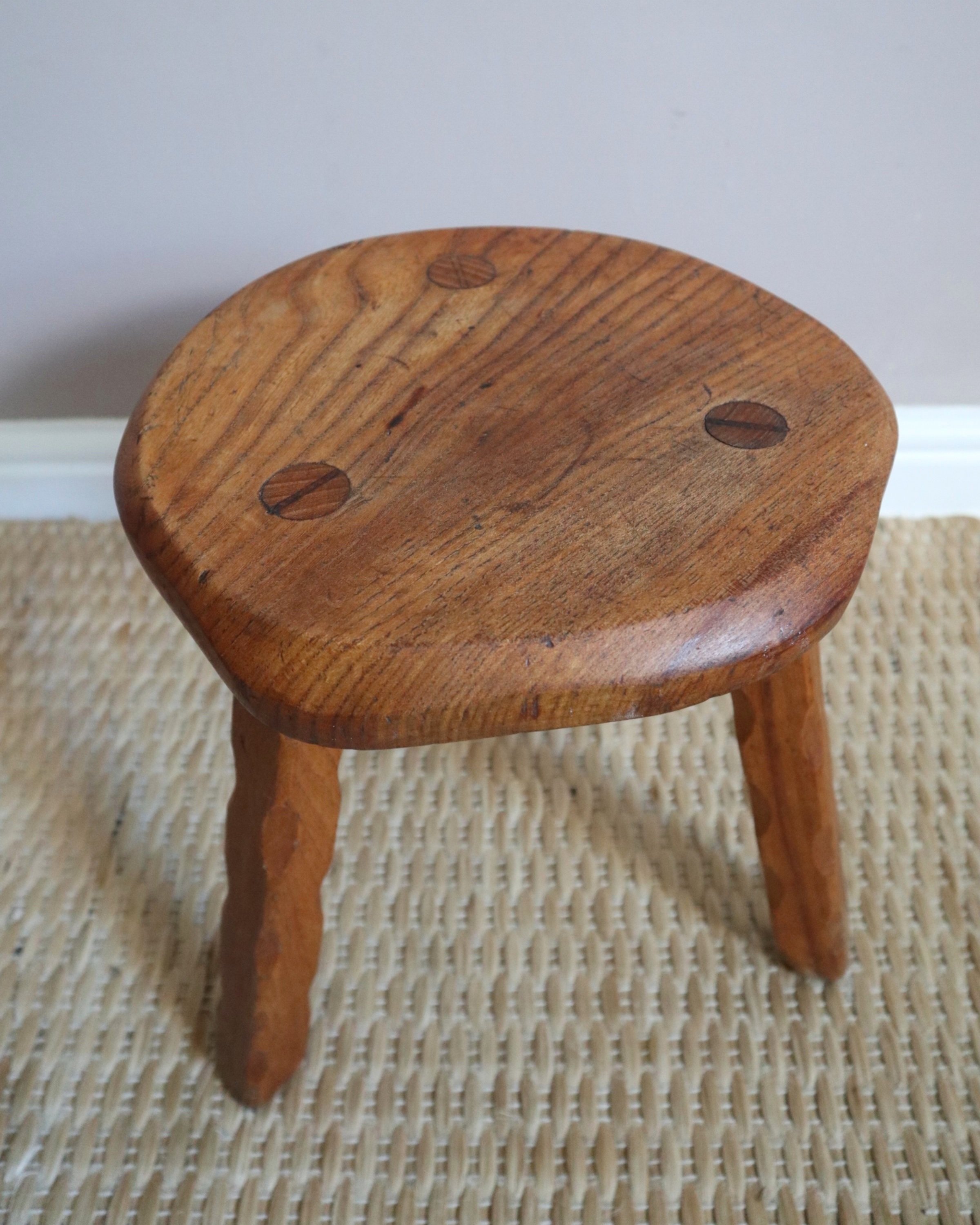 Vintage rustic handmade warm wooden tripod stool with carved legs. Stamped 'John Chapman Woodcrafts Northwood'.