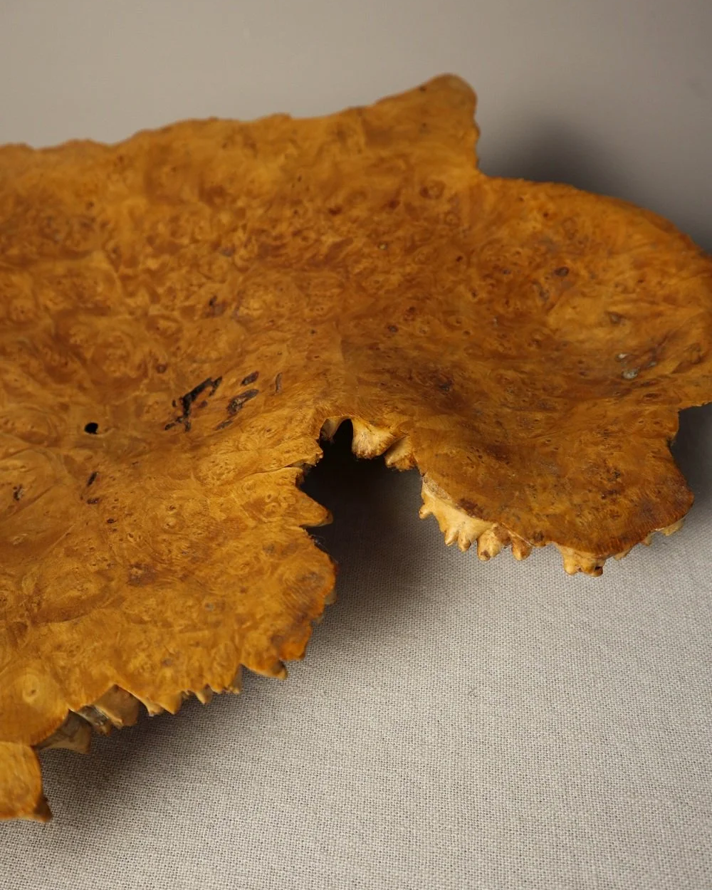 Decorative hand carved golden toned burr wood centrepiece dish with polished centre and organic naturalistic outside.