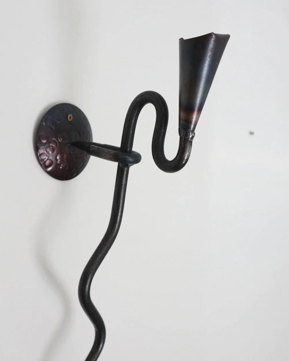 Large Swedish black iron wall sconce candleholder with wavy design. Circa 1960s.