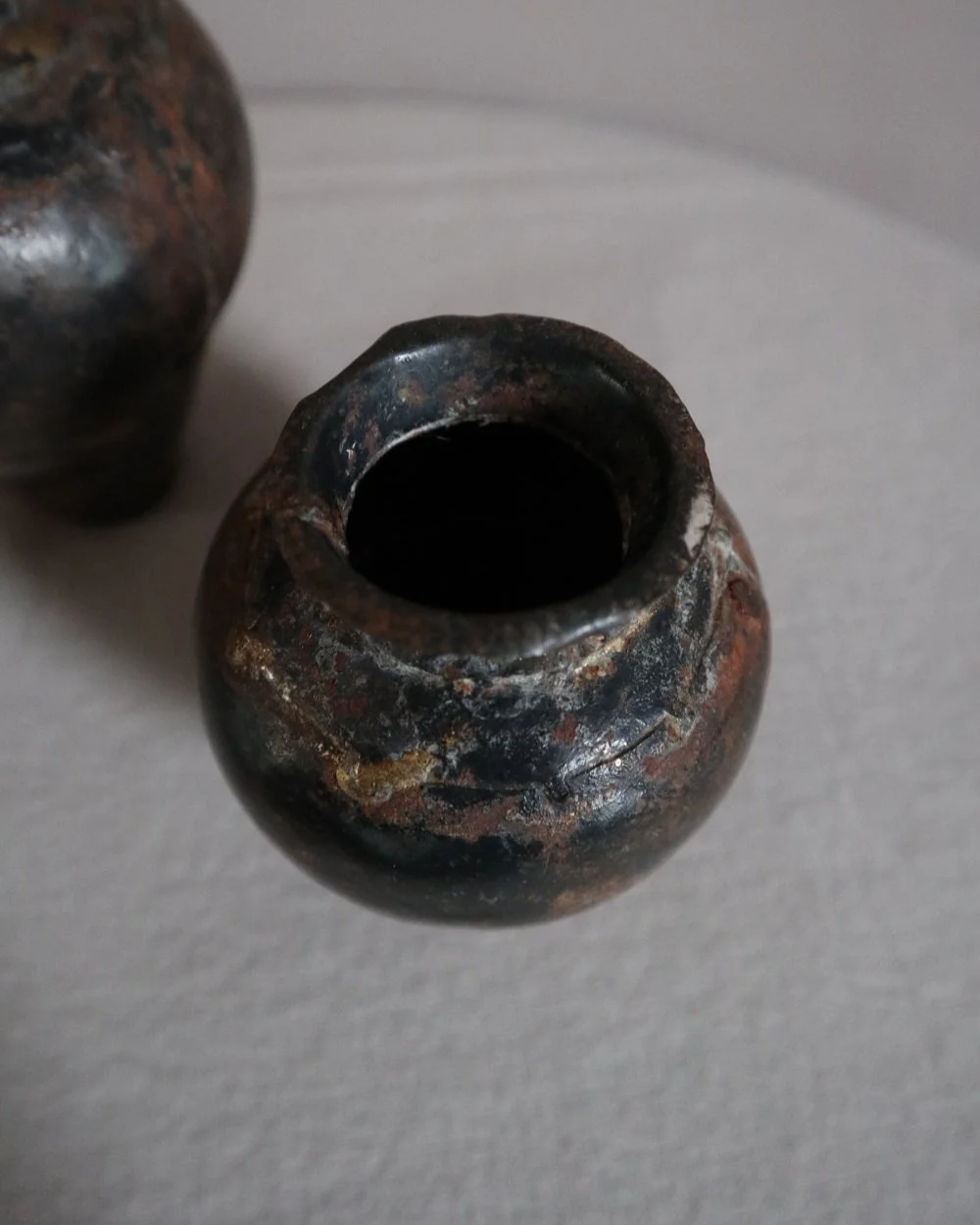 Set of two small, lightweight handmade metal vases of varying sizes.