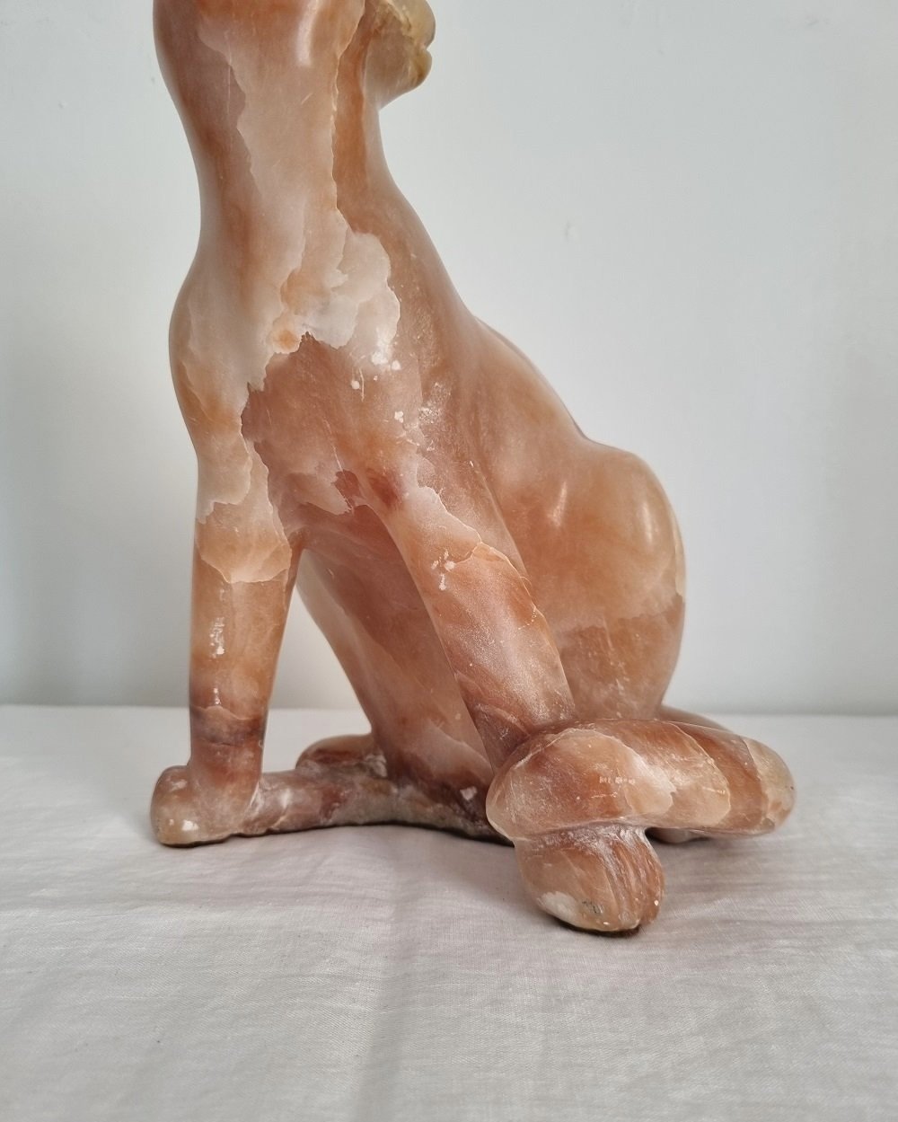 Vintage, heavy hand carved soft pink alabaster cat with striking natural grain and smooth lines.