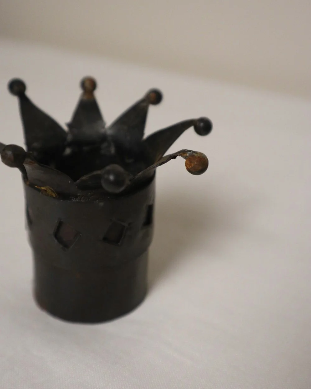 Pair of Modernist style, small dark metal jester hat or crown shaped tea light holders with diamond cut outs.