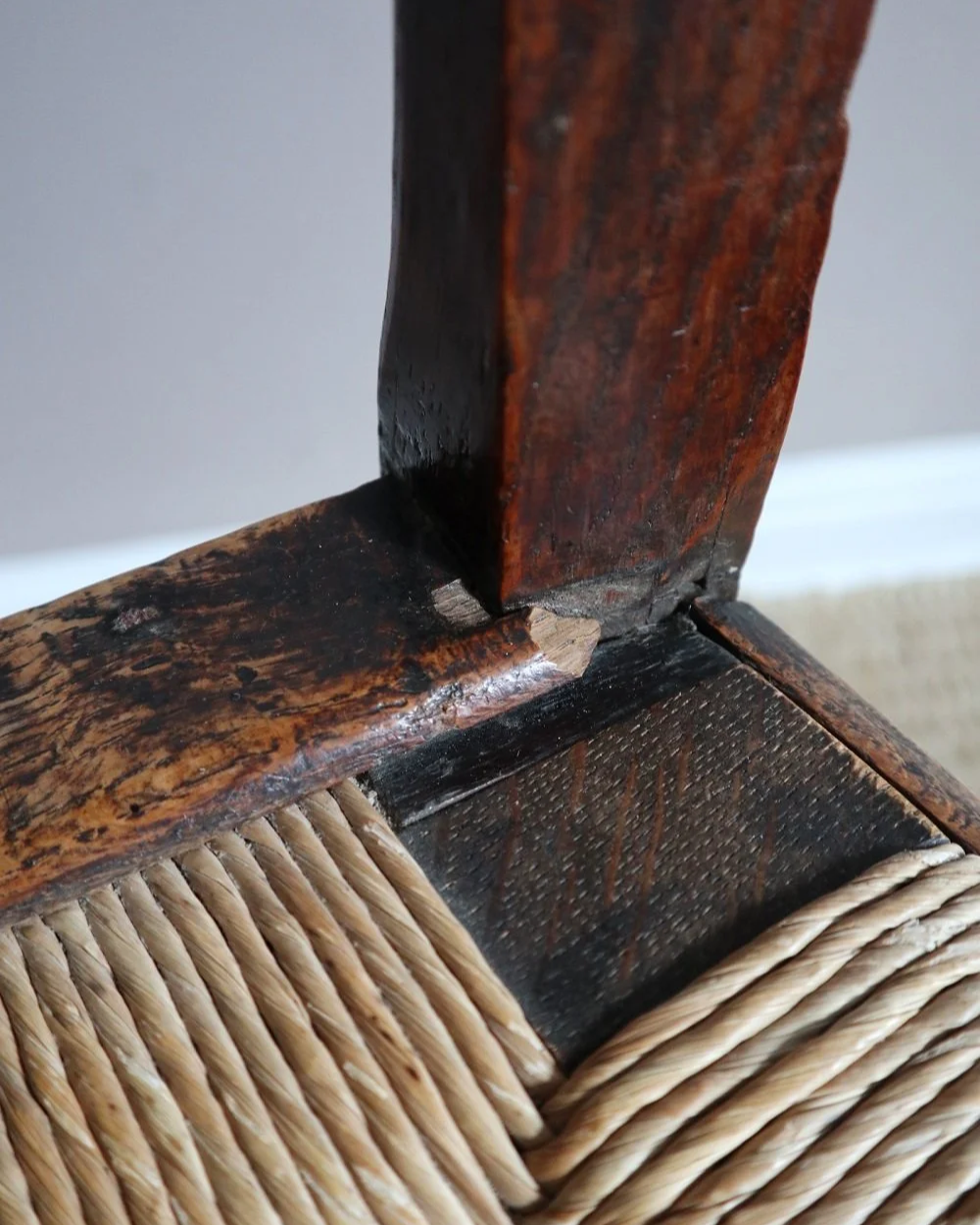 Pair of sculptural rustic oak ladder back dining chairs with rush seats, circa 1930s.