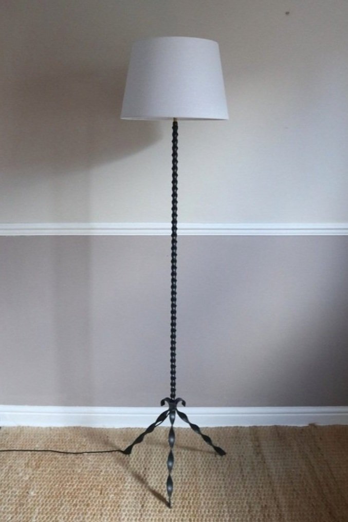 French wrought iron floor lamp with twisted corkscrew column and tripod base. Circa 1950s.