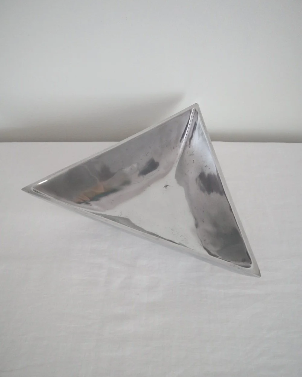 Solid shiny aluminium triangular Modernist style dish.