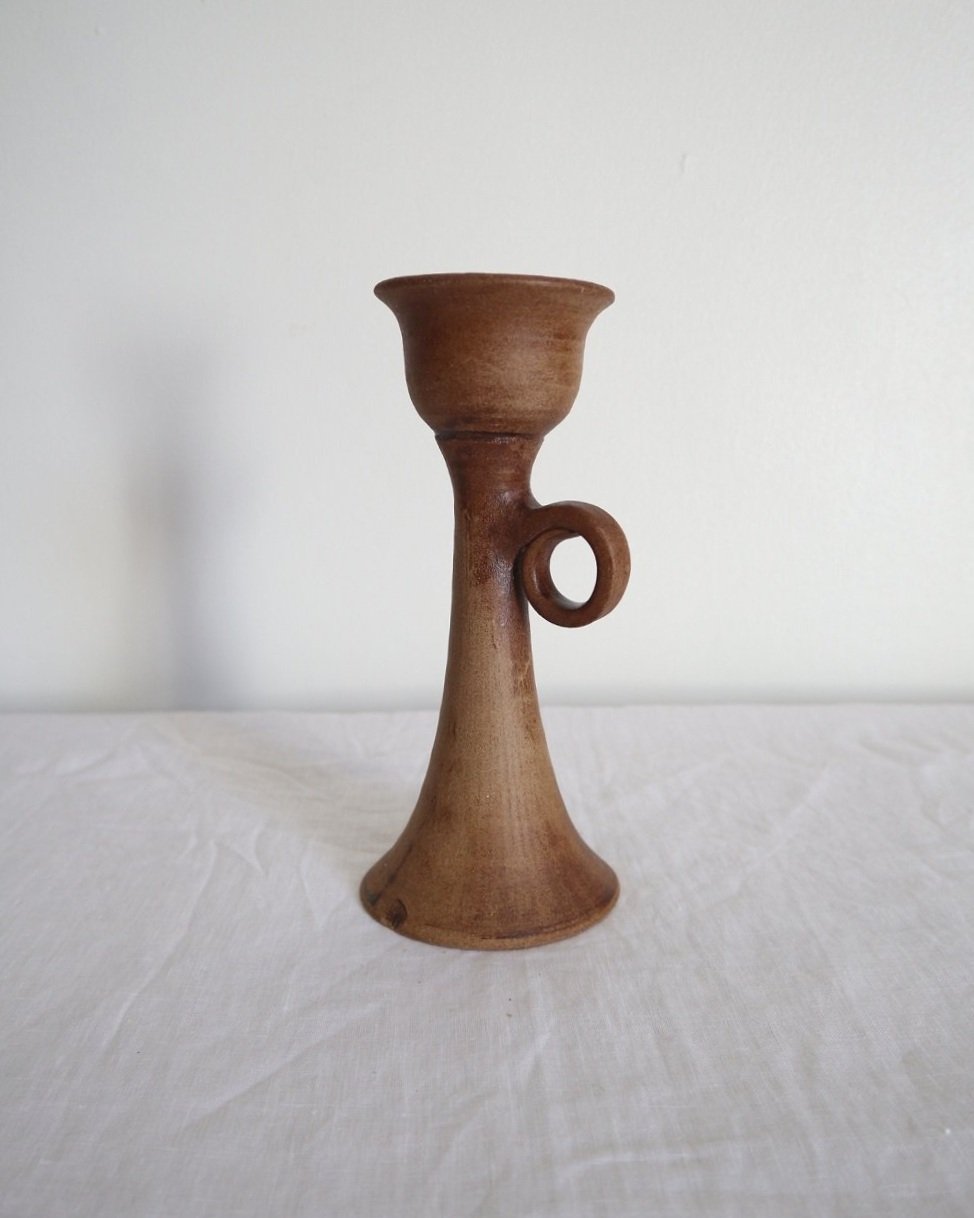 Rustic handmade studio pottery sculptural candleholder with curled circular handle.