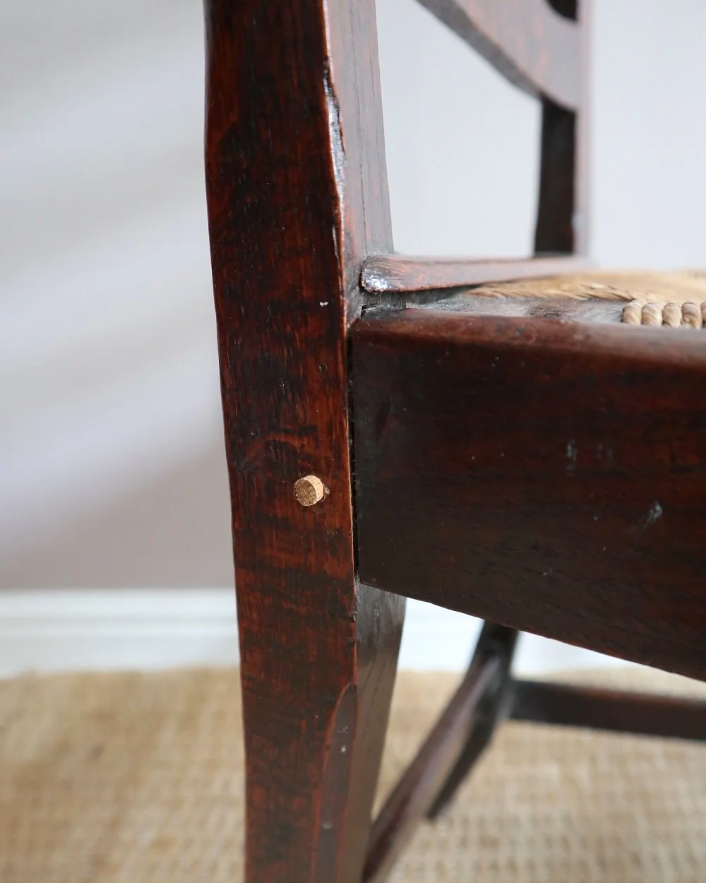 Pair of sculptural rustic oak ladder back dining chairs with rush seats, circa 1930s.
