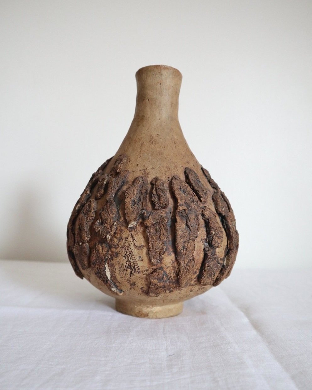 Studio pottery brown ceramic decorative vase with textured, tree bark effect decorations and a tapered neck. Age unknown.