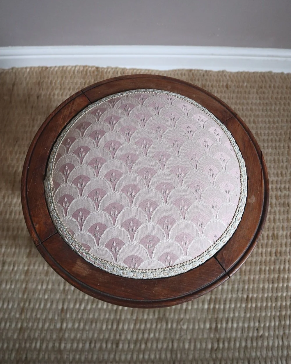 Antique Regency style carved wooden stool with four reeded tapered legs and dusky pink patterned upholstered seat.