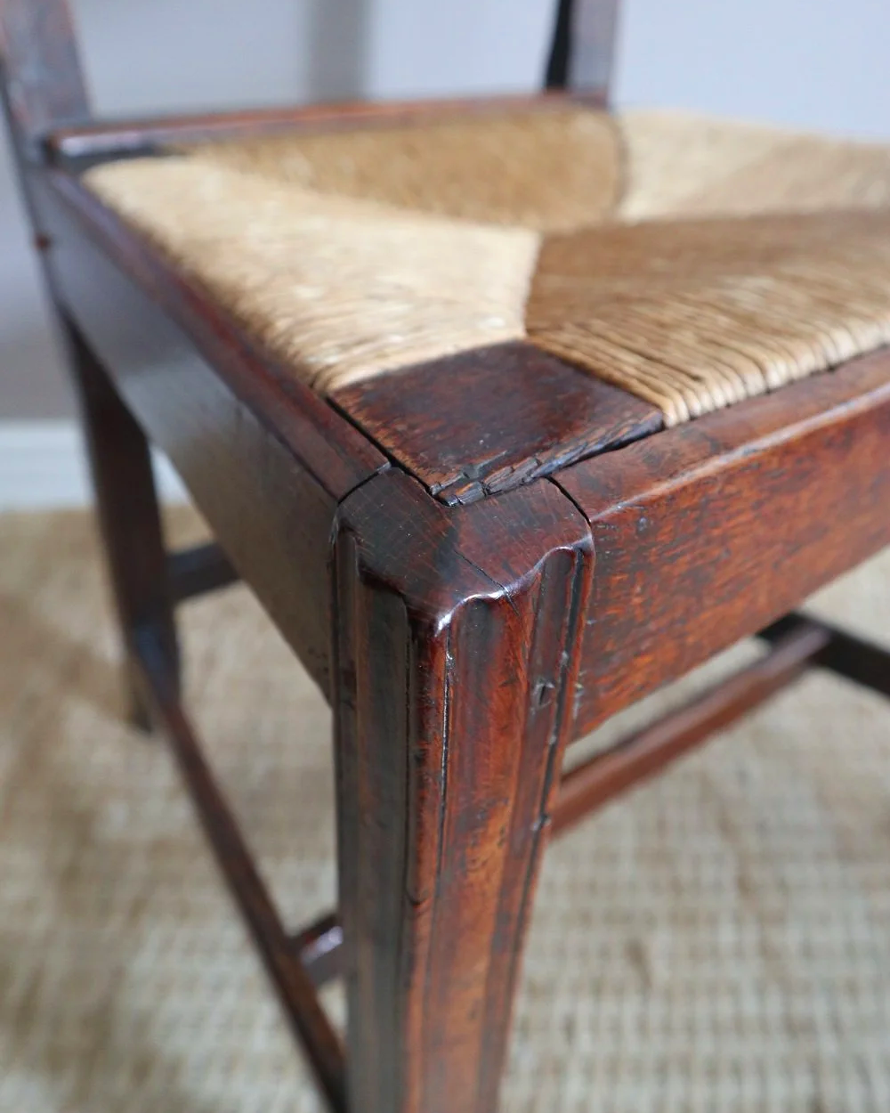 Pair of sculptural rustic oak ladder back dining chairs with rush seats, circa 1930s.