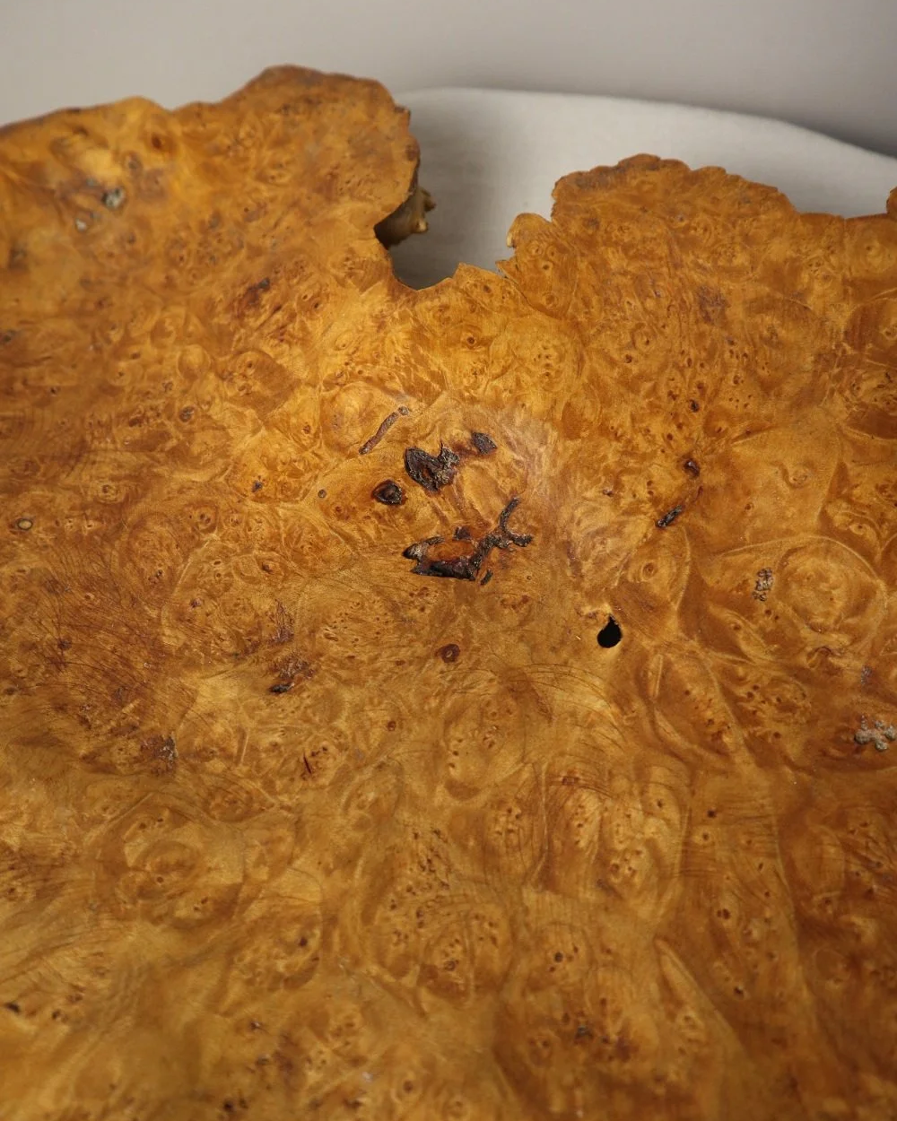 Decorative hand carved golden toned burr wood centrepiece dish with polished centre and organic naturalistic outside.