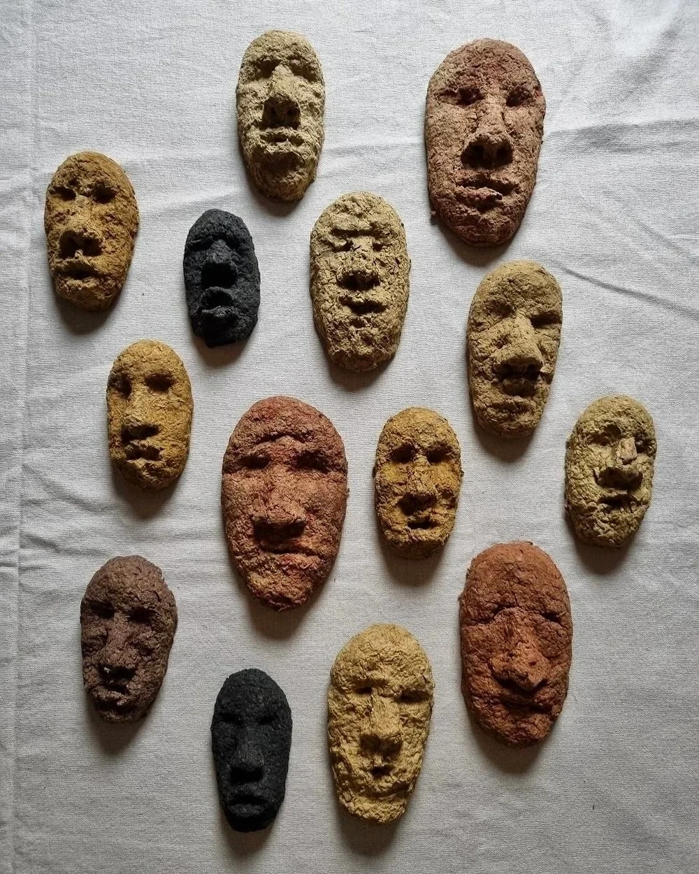 Set of unique handmade textured papier mache faces in earthy tones. Unknown age.  Unknown artist.