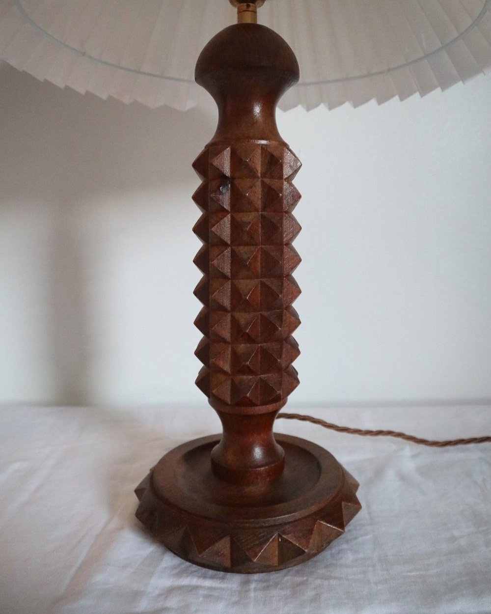 French Charles Dudouyt style carved wooden Brutalist table lamp with new, white pleated lampshade.