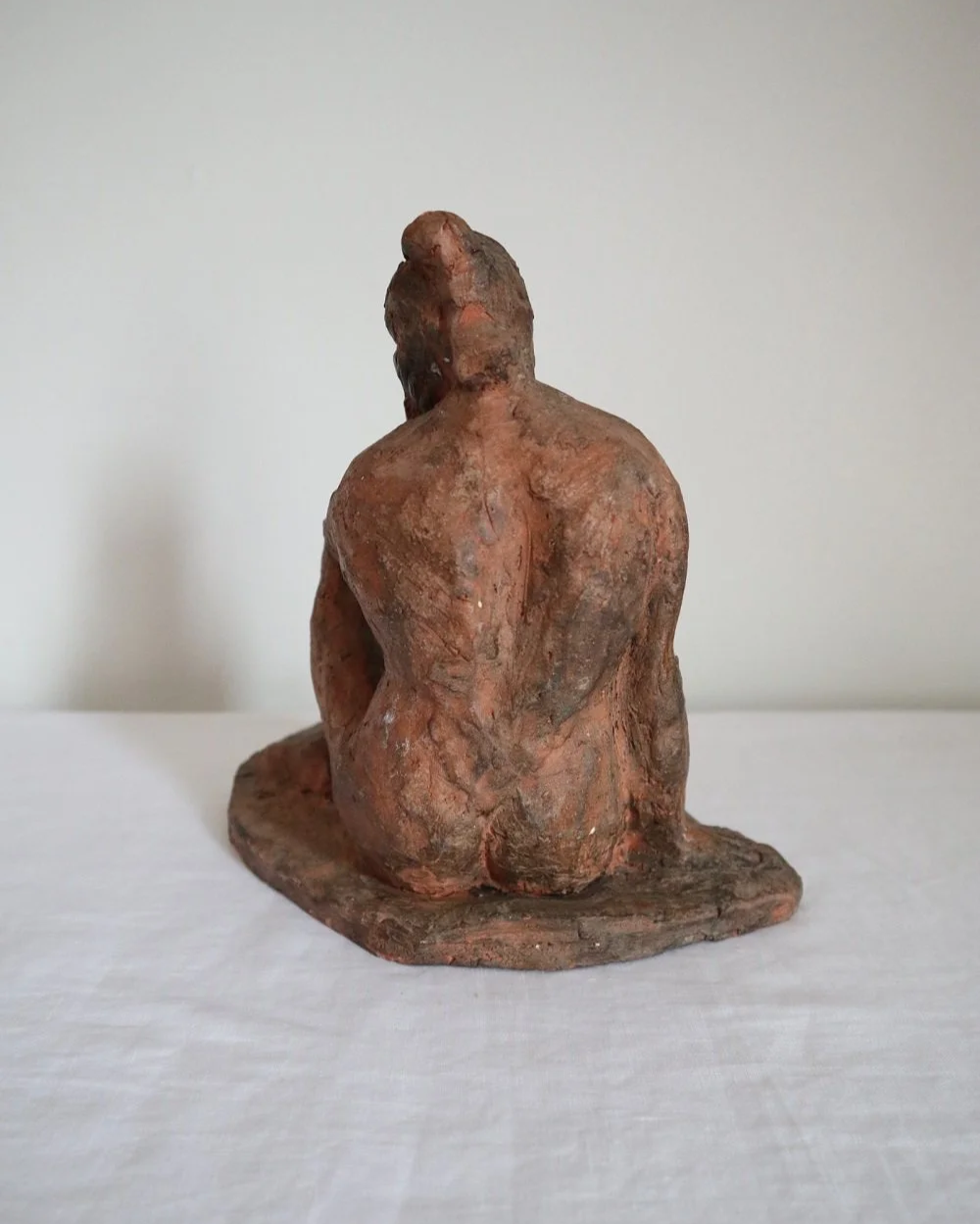 Heavy handmade studio pottery textured sculpture of seated nude woman.