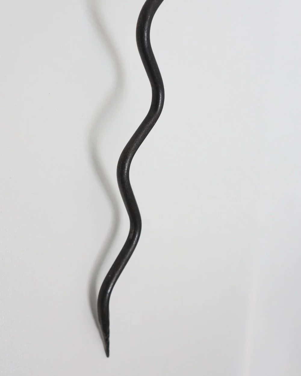 Large Swedish black iron wall sconce candleholder with wavy design. Circa 1960s.