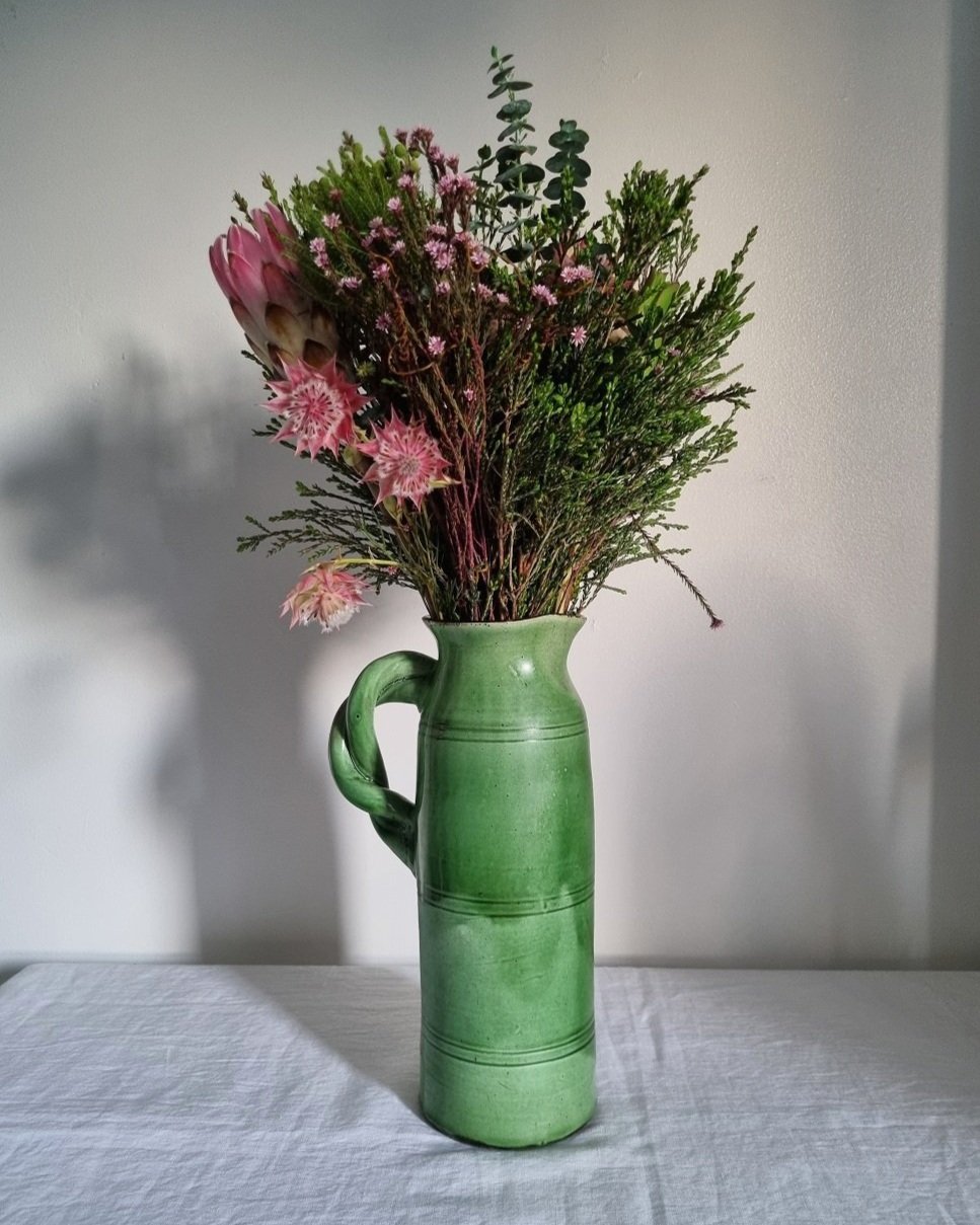 Tall studio pottery leaf green glazed water pitcher jug with twisted handle and banded centre. Marked Schofield Penrith.