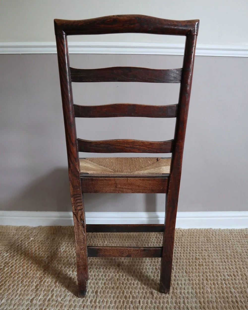 Pair of sculptural rustic oak ladder back dining chairs with rush seats, circa 1930s.