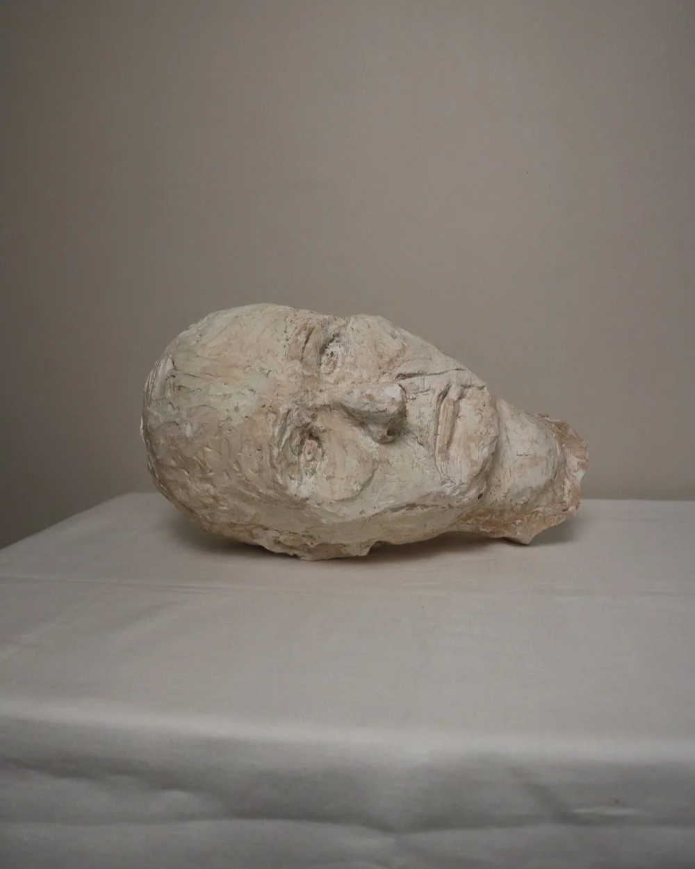 Large, heavy off white textured plaster sculpture of man's head in abstract style. Unknown age.