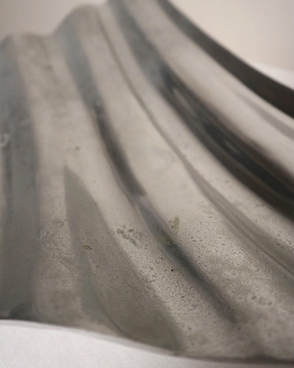 Large mid century, shiny cast aluminium triangular display dish with wavy edge.