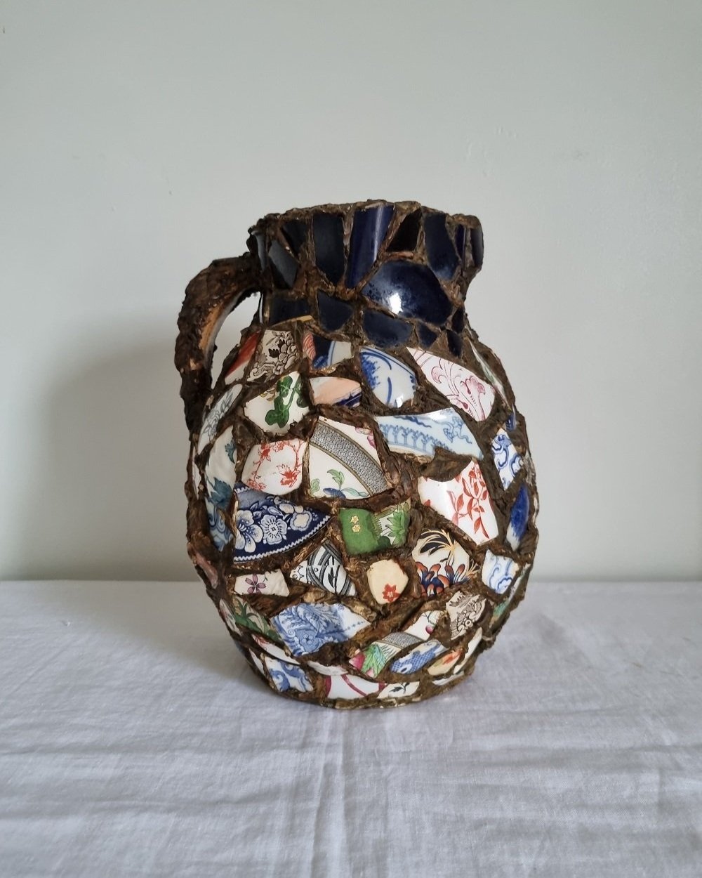 Large French pique assiette mosaic pottery jug with handle.