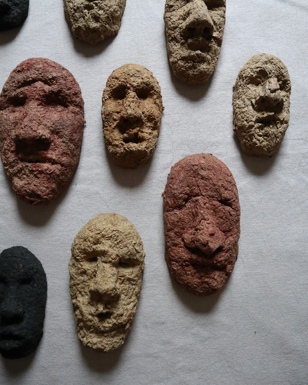Set of unique handmade textured papier mache faces in earthy tones. Unknown age.  Unknown artist.