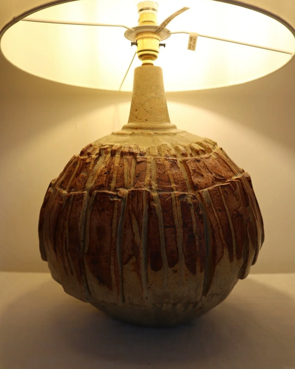 Large mid century Brutalist Bernard Rooke spherical art pottery table lamp with graduated slab sections and matt brown glaze. England, circa 1960s.