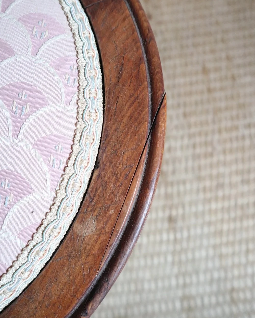Antique Regency style carved wooden stool with four reeded tapered legs and dusky pink patterned upholstered seat.