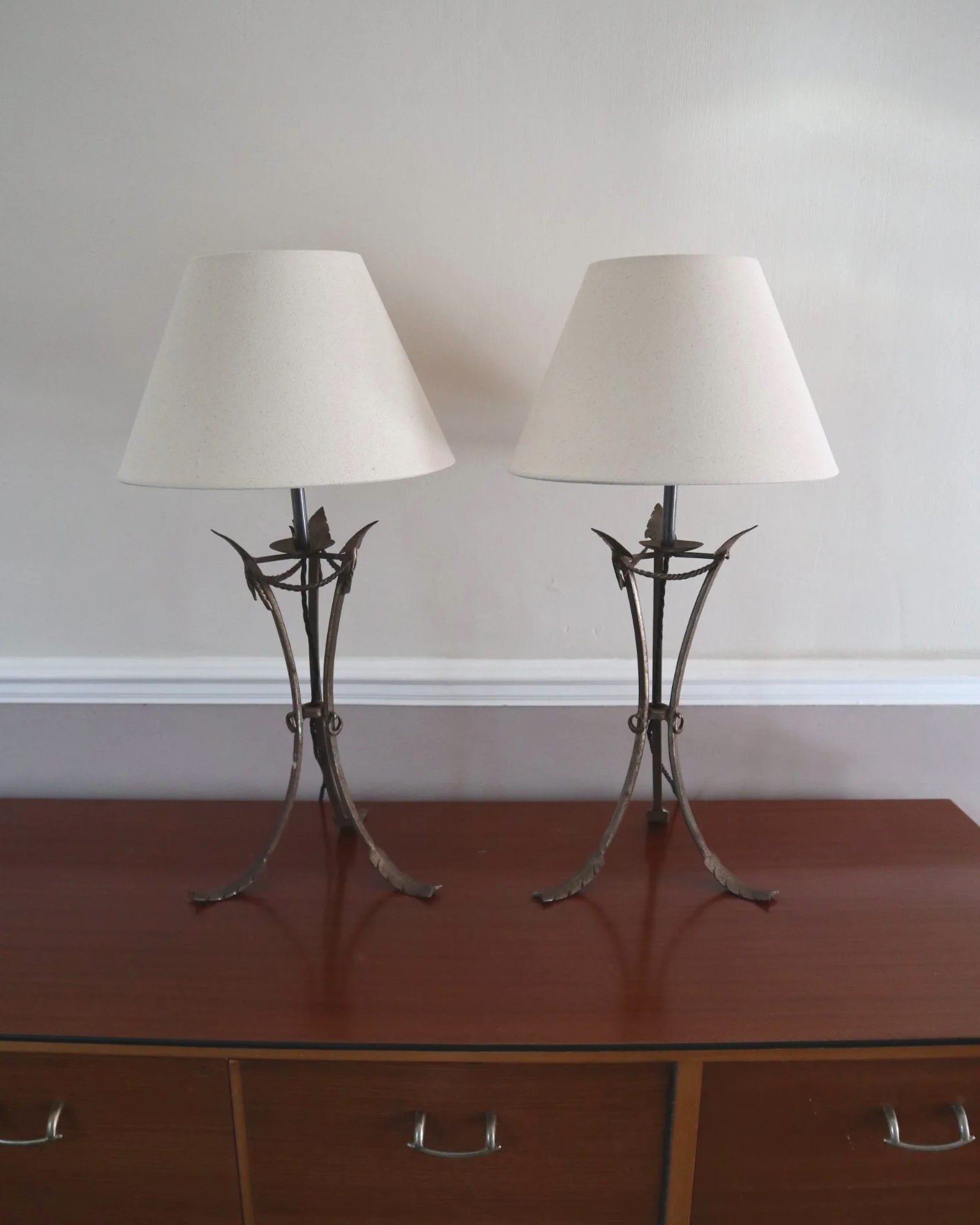Pair of French style mid century metal tripod table lamps featuring three arrows.