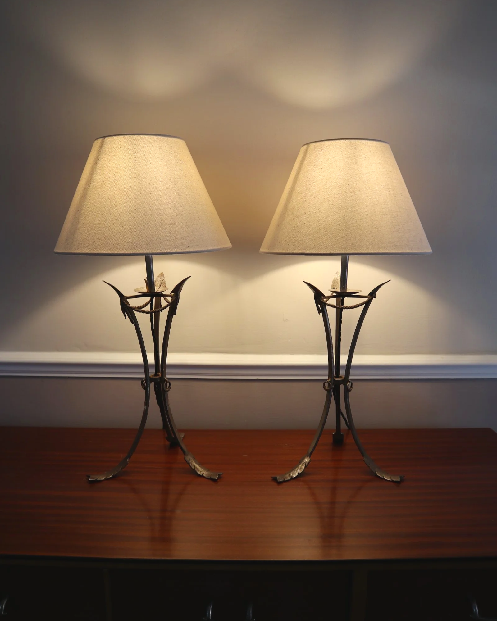 Pair of French style mid century metal tripod table lamps featuring three arrows.