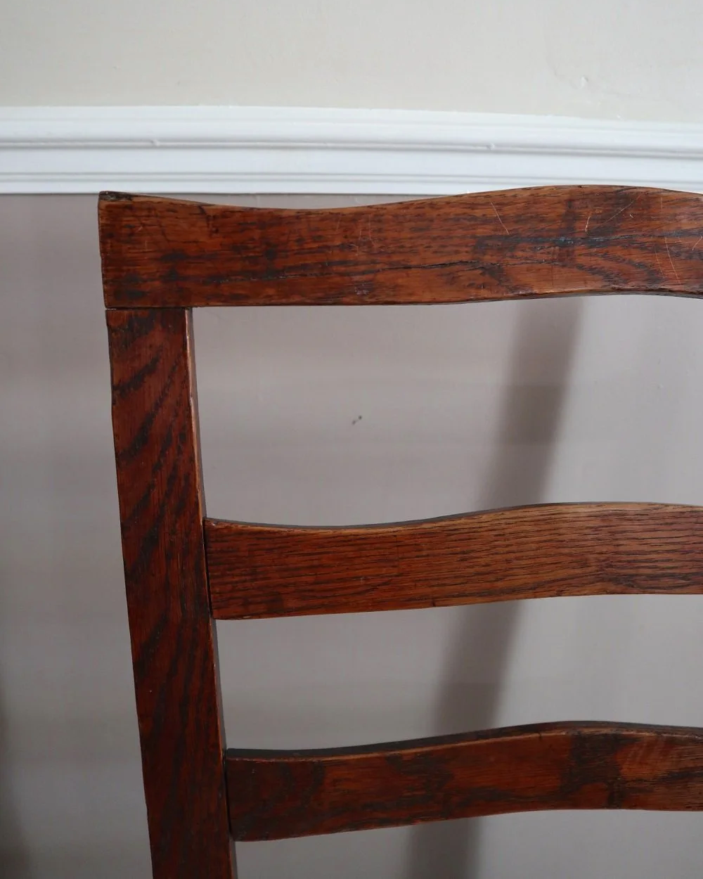 Pair of sculptural rustic oak ladder back dining chairs with rush seats, circa 1930s.