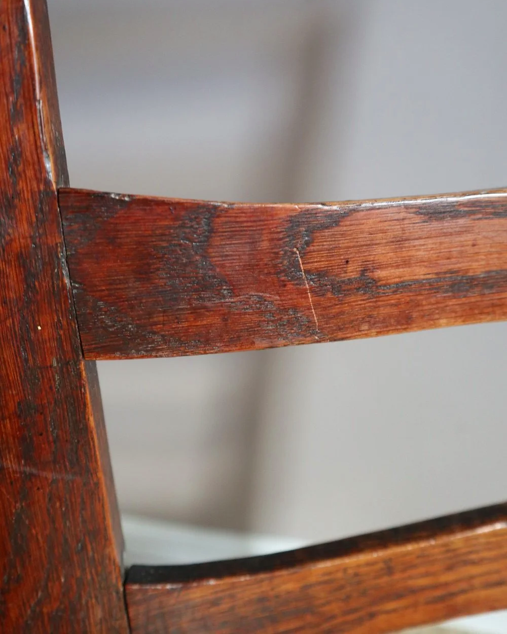 Pair of sculptural rustic oak ladder back dining chairs with rush seats, circa 1930s.
