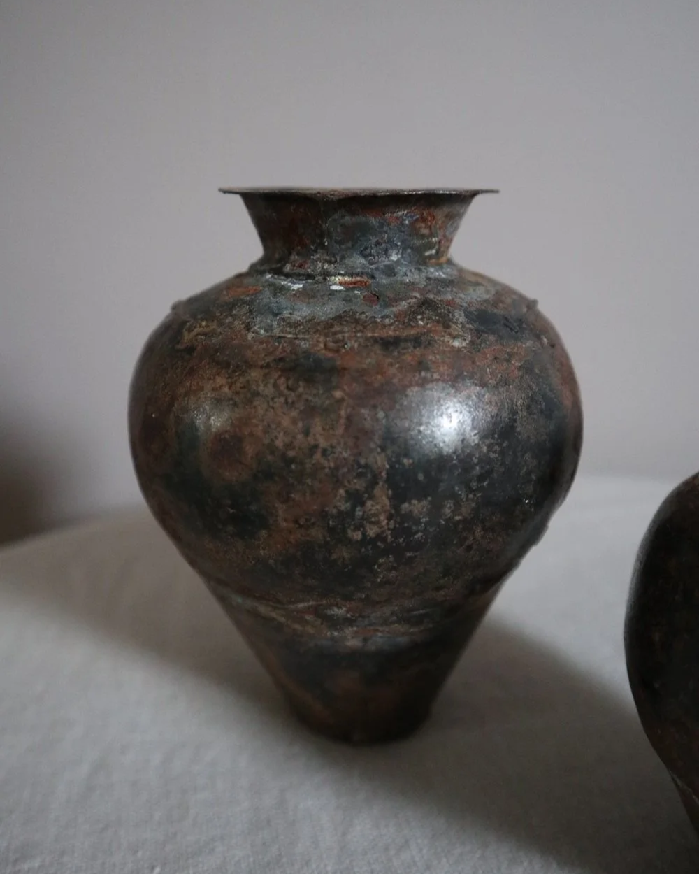 Set of two small, lightweight handmade metal vases of varying sizes.