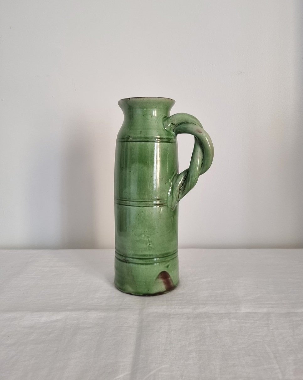 Tall studio pottery leaf green glazed water pitcher jug with twisted handle and banded centre. Marked Schofield Penrith.