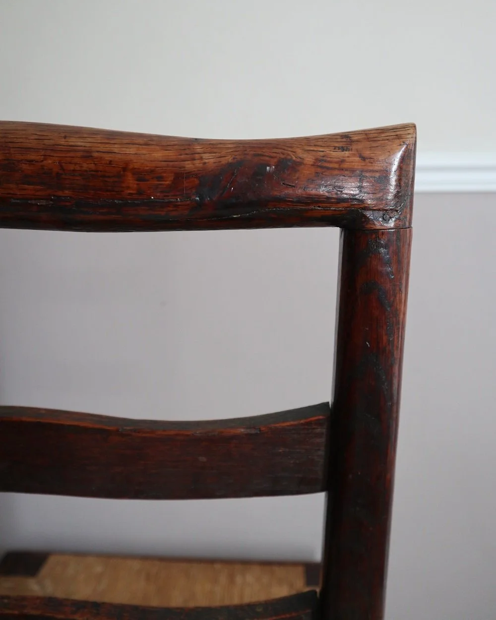 Pair of sculptural rustic oak ladder back dining chairs with rush seats, circa 1930s.
