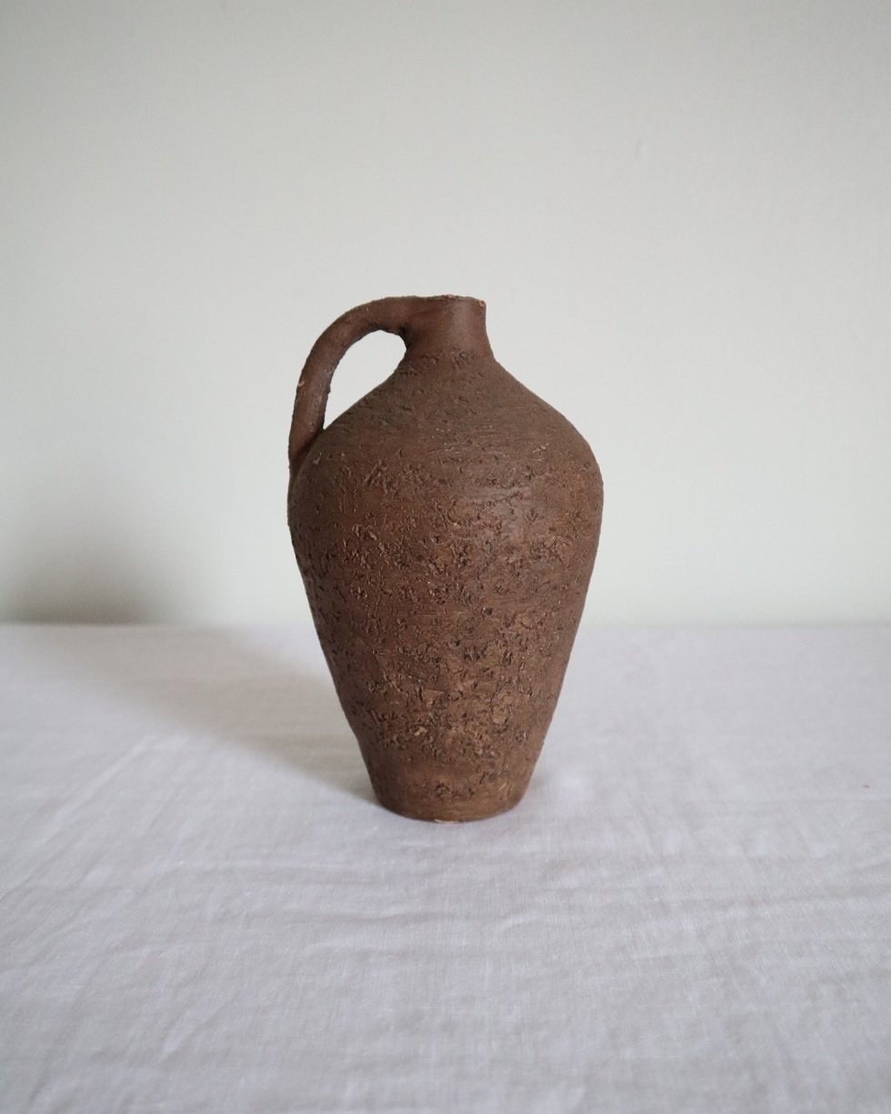 Mid century Brutalist sculptural textured brown ceramic decorative vessel or bud vase. Circa 1970s. Signed “CP”, likely the work of American potter Karl Martz for Clayburn Pottery.