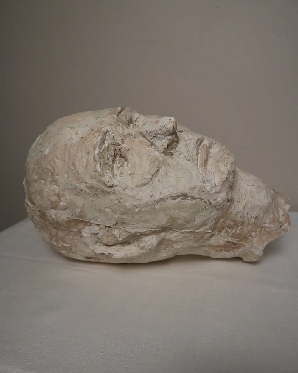 Large, heavy off white textured plaster sculpture of man's head in abstract style. Unknown age.