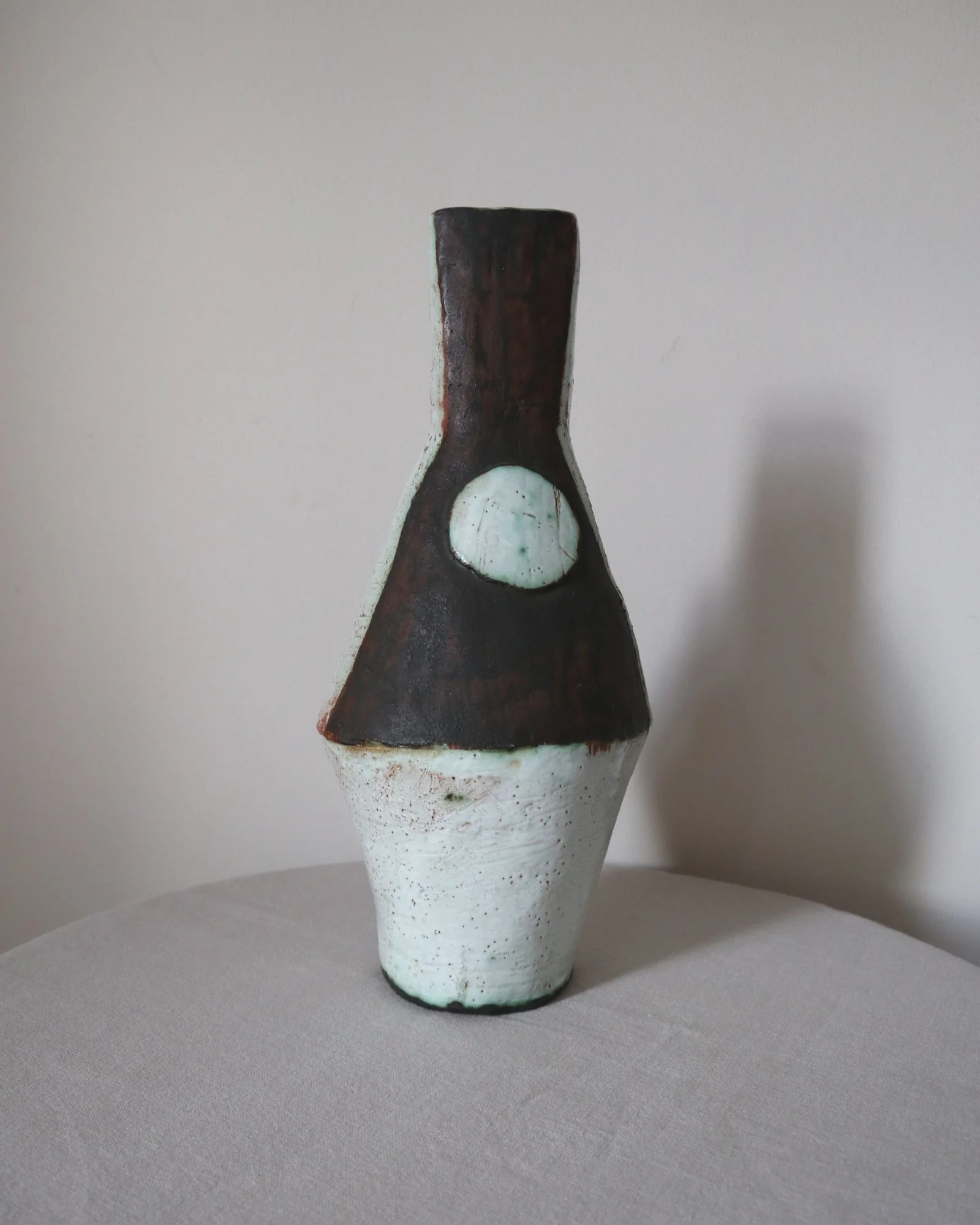 Vintage hand-built ceramic Brutalist art vase, featuring an abstract, asymmetrical design with textured white, dark brown, and subtle green glazes.