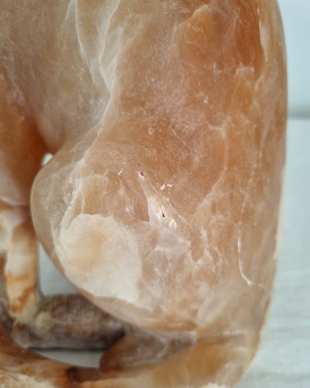 Vintage, heavy hand carved soft pink alabaster cat with striking natural grain and smooth lines.