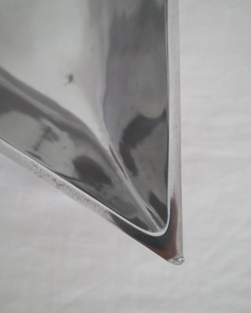 Solid shiny aluminium triangular Modernist style dish.