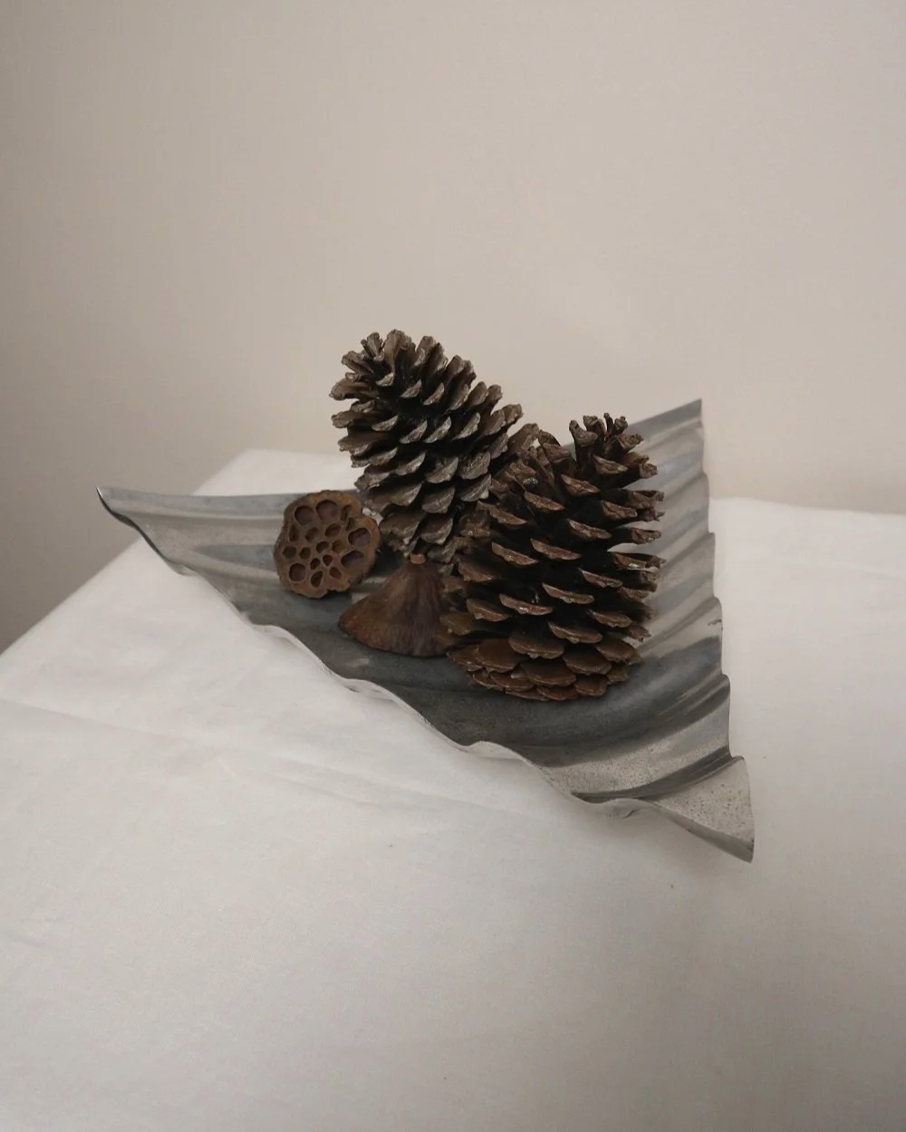 Large mid century, shiny cast aluminium triangular display dish with wavy edge.