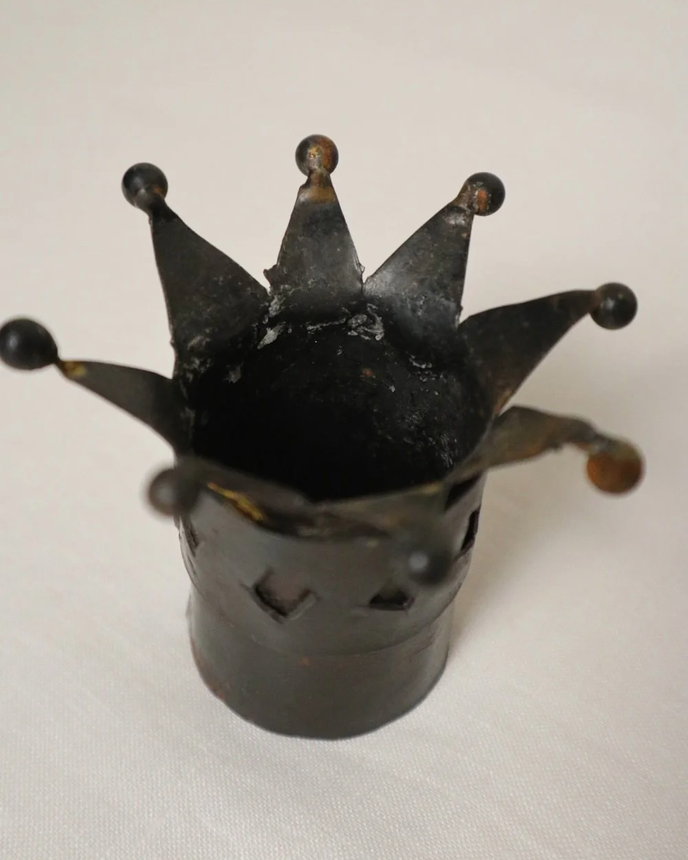 Pair of Modernist style, small dark metal jester hat or crown shaped tea light holders with diamond cut outs.