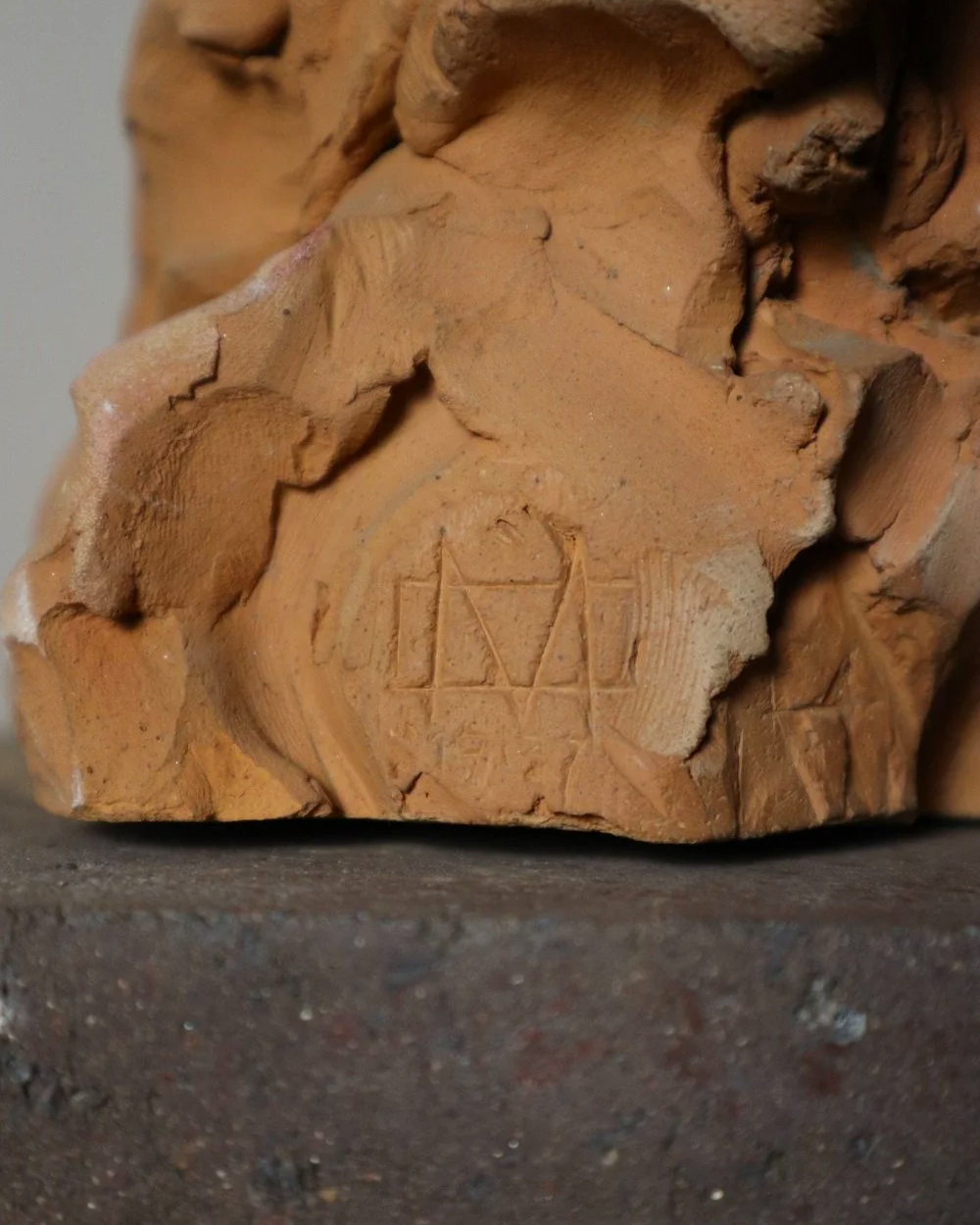 A signed, 20th century art studio terracotta female bust with stone display plinth.