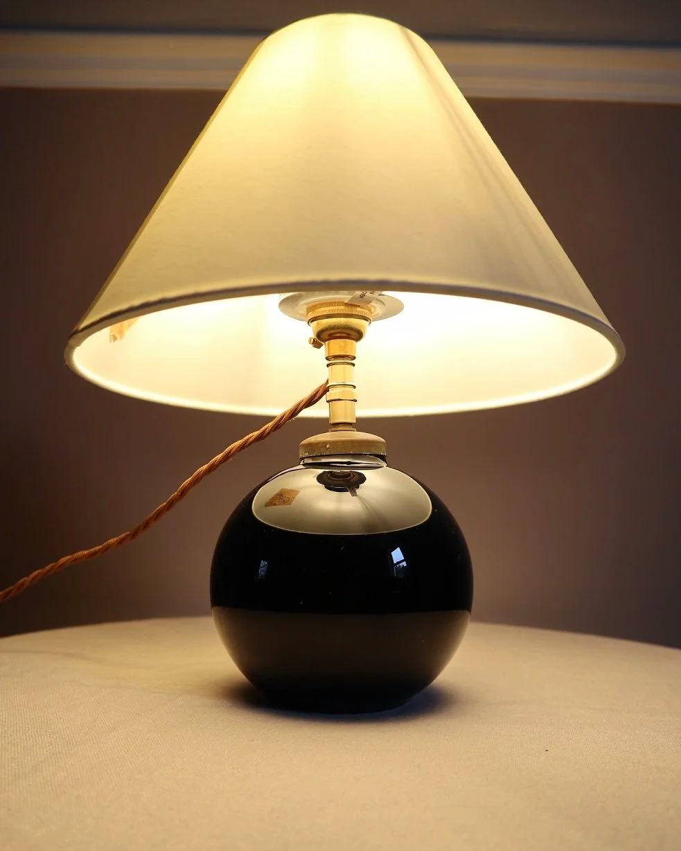 Small, Art Deco black glass ball lamp in the style of Jacques Adnet. Circa 1930s.