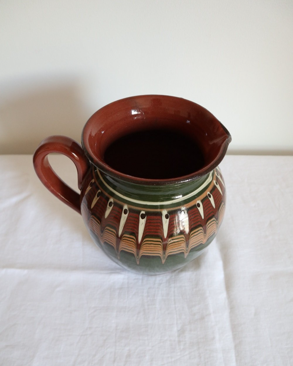 Large Bulgarian green and brown ceramic pitcher jug in traditional Troyan style.