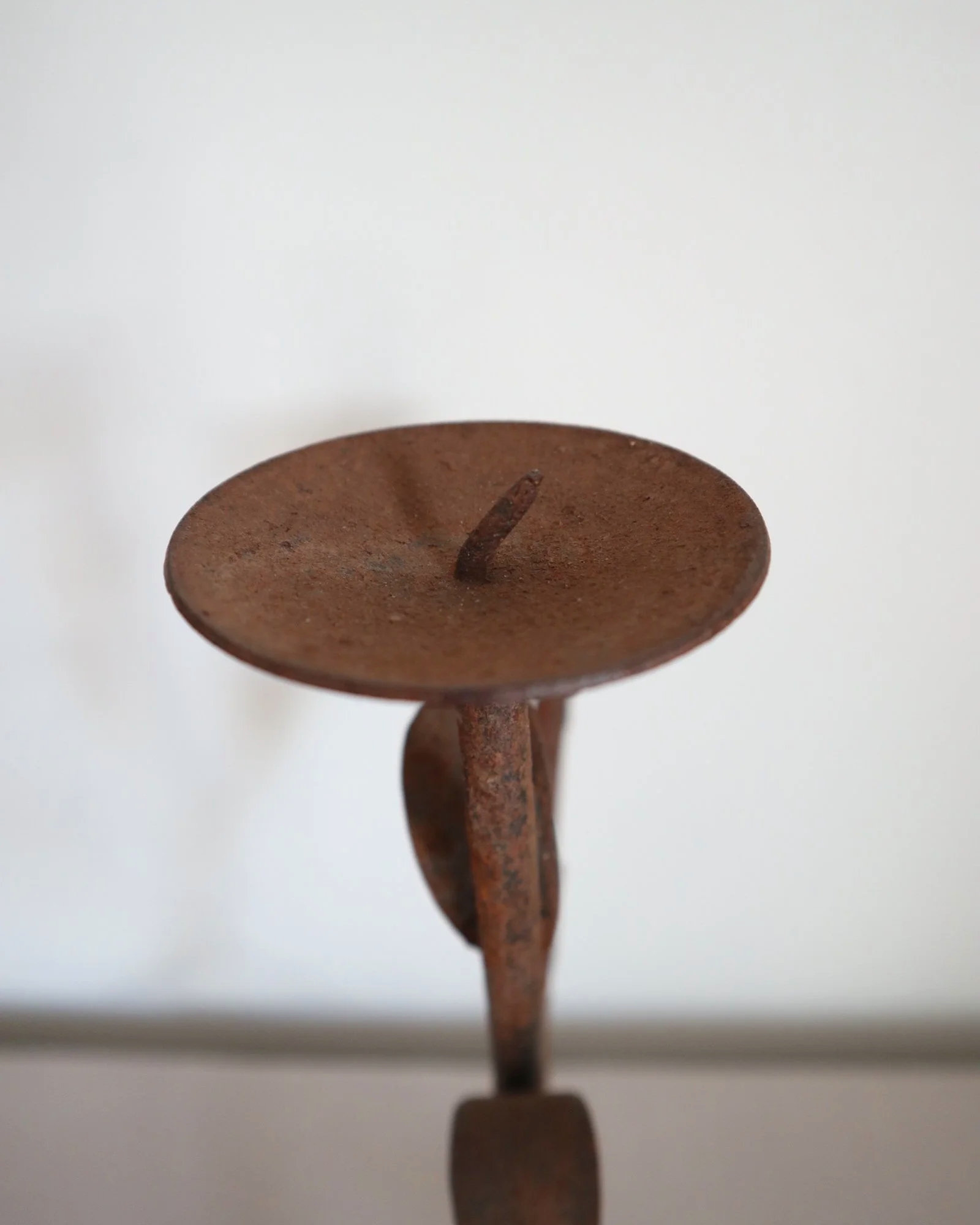 Pair of mid-century, sculptural hand crafted wrought iron 3-arm candle holders with decorative leaves and four footed base.