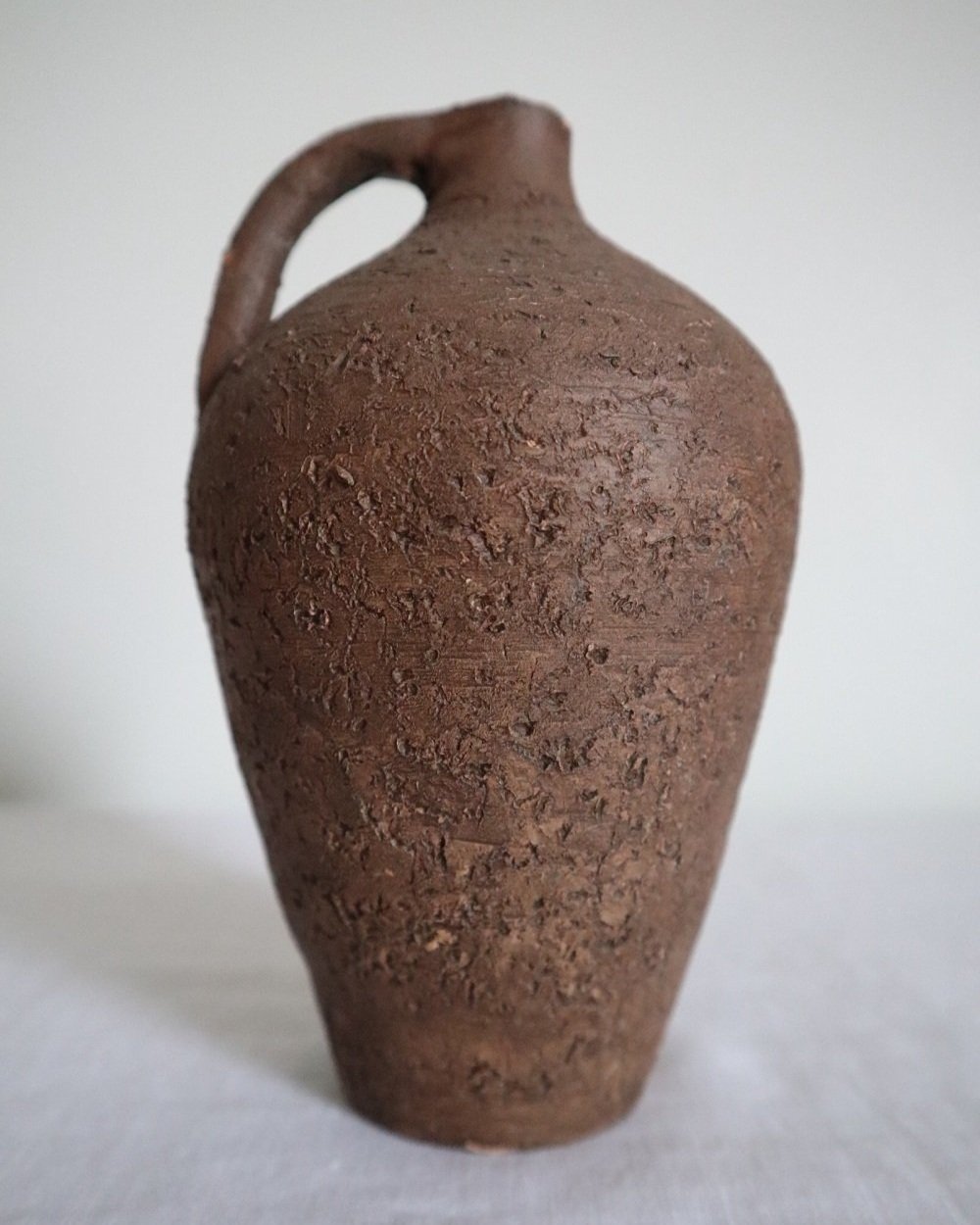 Mid century Brutalist sculptural textured brown ceramic decorative vessel or bud vase. Circa 1970s. Signed “CP”, likely the work of American potter Karl Martz for Clayburn Pottery.